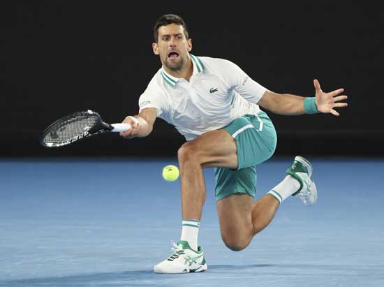 Serbia's Novak Djokovic hits a forehand return to Canada's Milos Raonic during their fourth round match at the Australian Open tennis championship in Melbourne, Australia, Sunday, Feb. 14, 2021.(AP Photo/Hamish Blair)