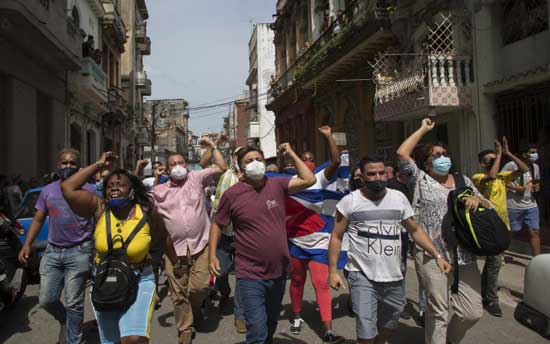 Government supporters shout slogans as anti-government protesters march in Havana, Cuba, Sunday, July 11, 2021. Hundreds of demonstrators went out to the streets in several cities in Cuba to protest against ongoing food shortages and high prices of foodstuffs. (AP Photo/Ismael Francisco)