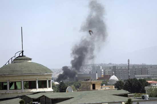 Smoke rises next to the U.S. Embassy in Kabul, Afghanistan, Sunday, Aug. 15, 2021. Taliban fighters entered the outskirts of the Afghan capital on Sunday, further tightening their grip on the country as panicked workers fled government offices and helicopters landed at the embassy. Wisps of smoke could be seen near the embassy's roof as diplomats urgently destroyed sensitive documents, according to two American military officials. (AP Photo/Rahmat Gul)