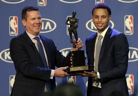 Golden State Warriors guard Stephen Curry, right, is presented with the NBA's Most Valuable Player award by Tim Chaney, of Kia Motors.
