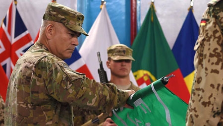 General John Campbell (L) rolls the flag of the NATO-led International Security Assistance Force (ISAF) during a ceremony marking the end of ISAF's combat mission in Afghanistan at ISAF headquarters in Kabul on December 28, 2014. 