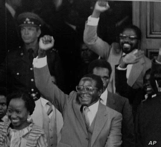 FILE - Zimbabwean Premier Robert Mugabe gives a triumphant salute as he emerges from Parliament following its official opening, May 14, 1980.
