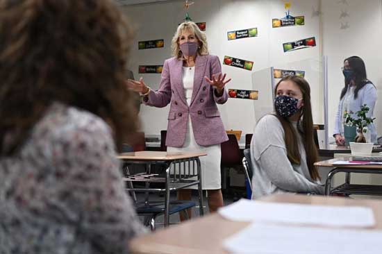 FILE - In this March 3, 2021, file photo speaks with students as she tours Fort LeBoeuf Middle School in Waterford, Pa. Jill Biden is going back to her whiteboard. After months of teaching writing and English to community college students in boxes on a computer screen, the first lady resumes teaching in person on Tuesday, Sept. 7, from a classroom at Northern Virginia Community College, where she has worked since 2009. (Mandel Ngan/Pool via AP, File)
