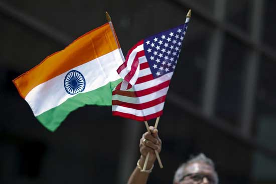 File photo: A man holds the flags of India and the U.S. while people take part in the 35th India Day Parade in New York August 16, 2015. Reuters image