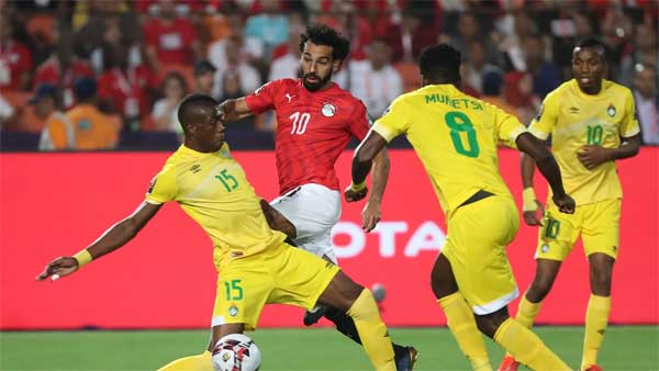 Egypt’s Mohammed Salah tries to work his way around three Zimbabwe players in the opening game of the tournament. Image credit - cafonline