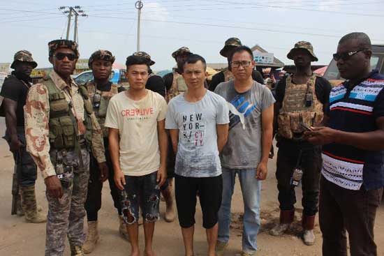 Ghanaian security officials with detained illegal Chinese miners. File image courtesy of Gh Headlines
