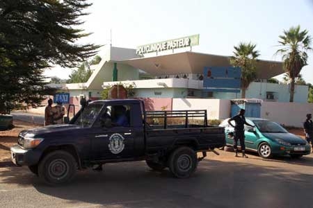 Police officers stand in front of the quarantined Pasteur clinic in Bamako on November 12, 2014